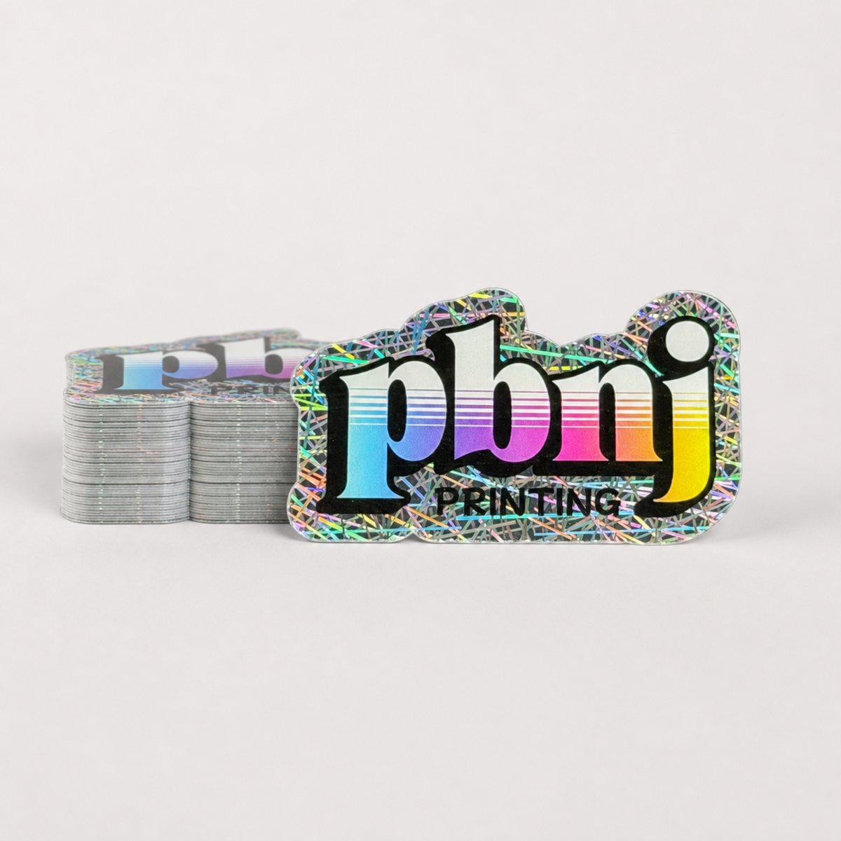 Stack of custom die cut stickers on Straw holographic material